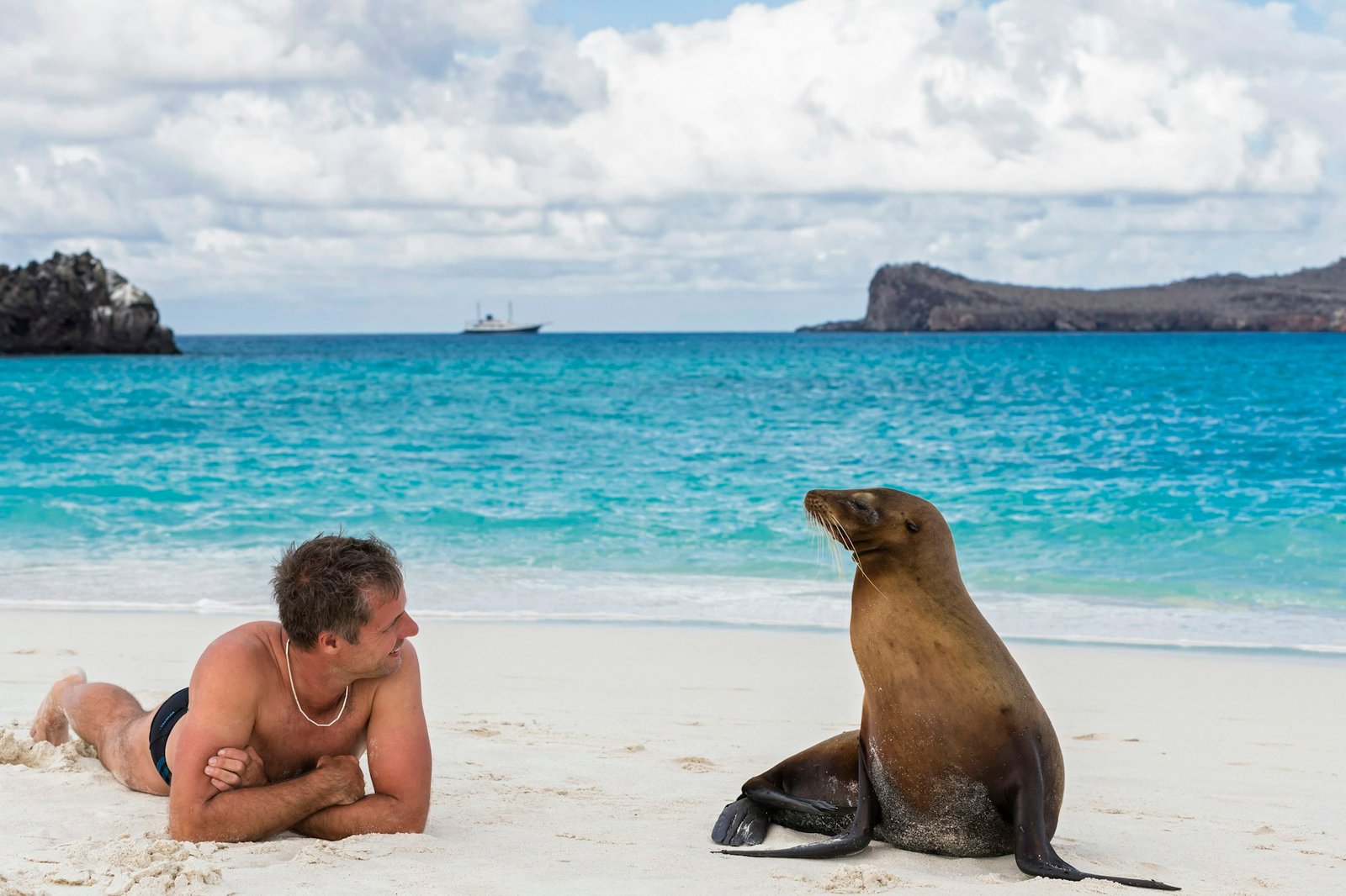 Ecuador, Galapagos Islands, Espanola, tourist and Galapagos sea lion on beach